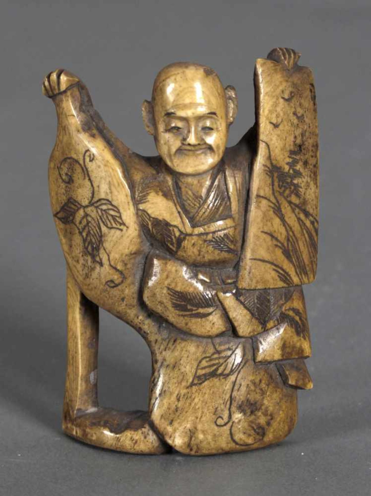 Netsuke eines sitzenden Mannes, 19. Jh.der zwei künstlerisch gestaltete Objekte (