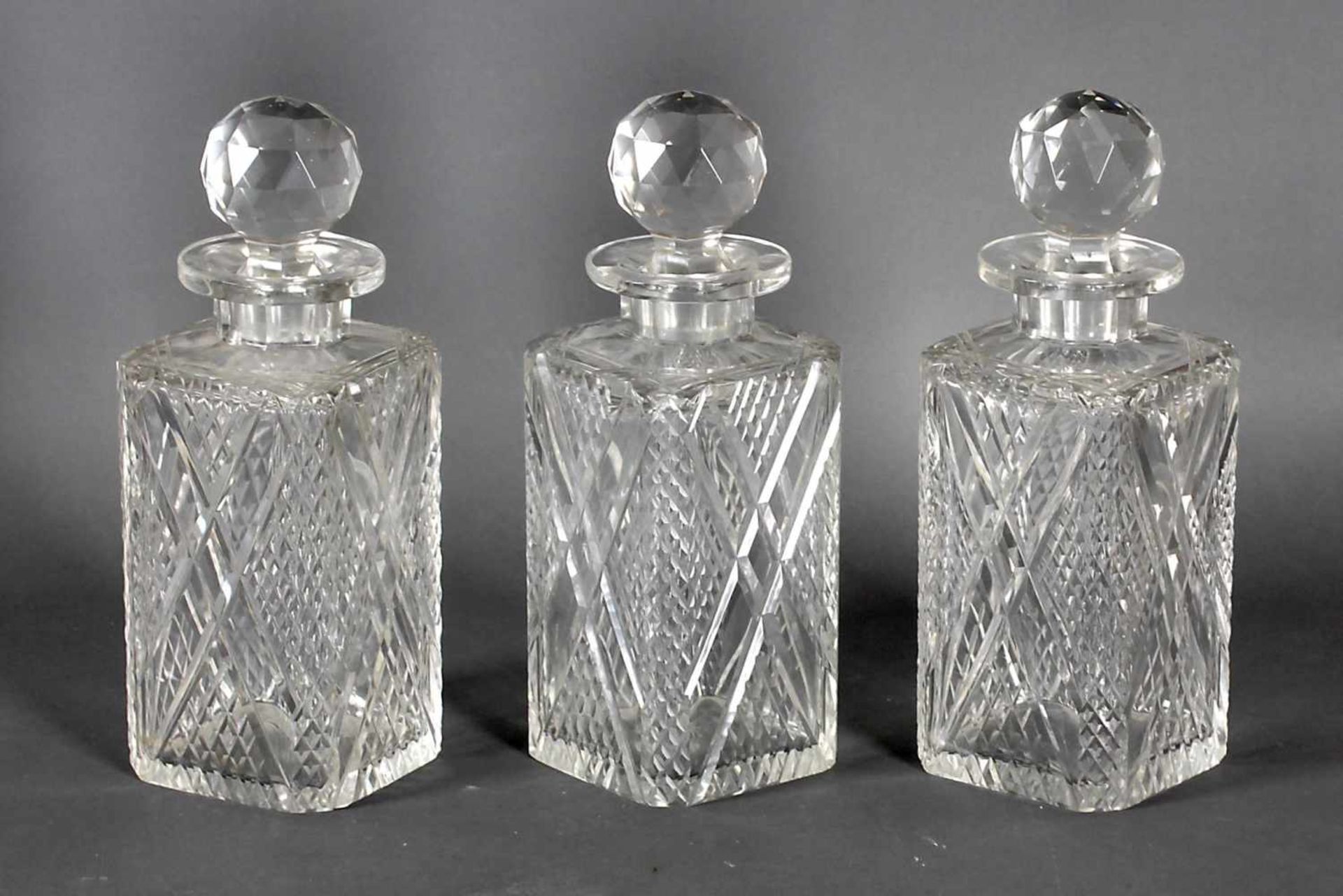 Drei Vierkantflaschen mit Stöpsel, deutsch Mitte 20. Jh.farbloses Glas jede mit eingeschliffenem