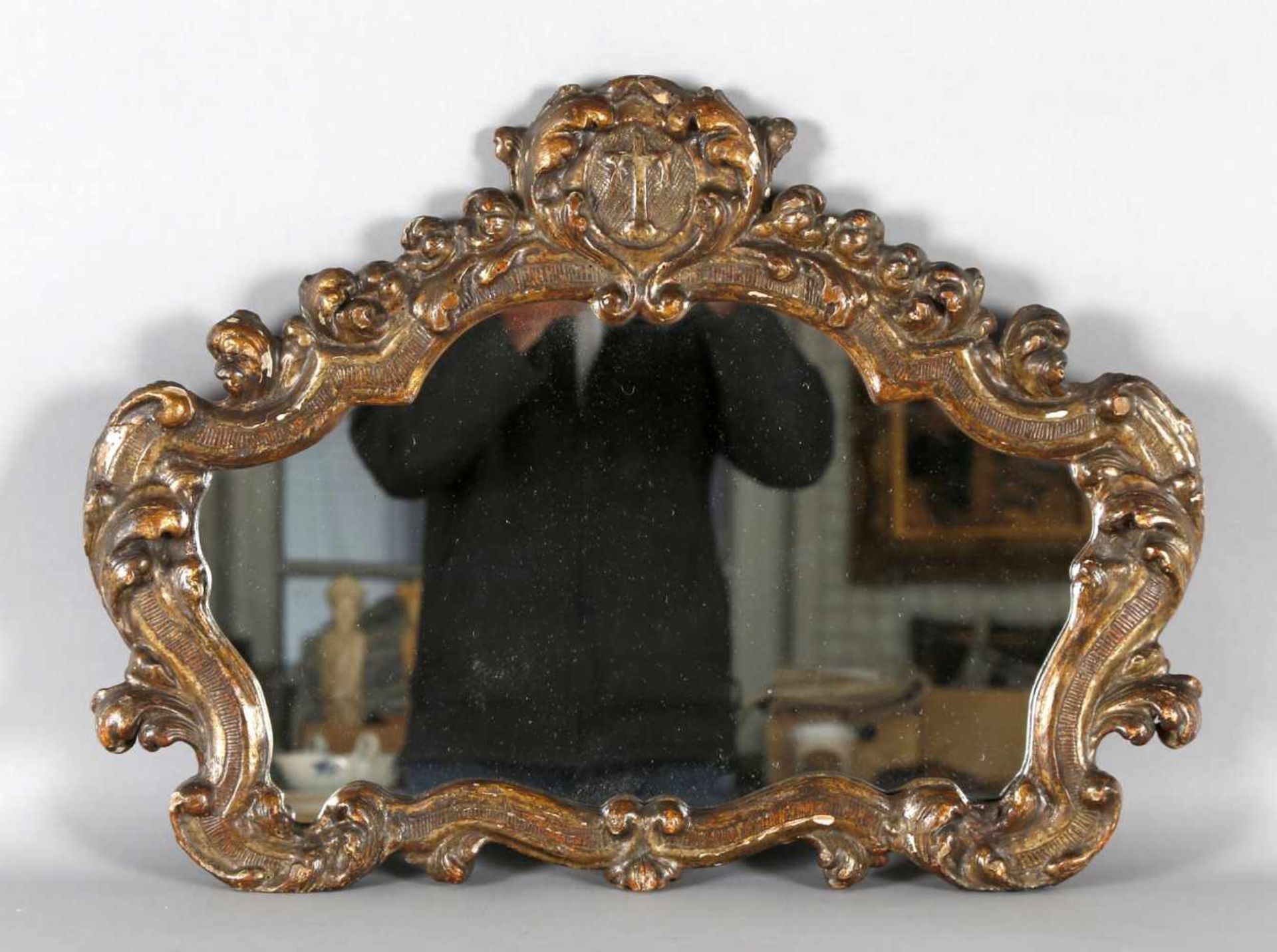 Geschweifter Spiegel, wohl noch 18. Jh.Holz geschnitzt und vergoldet, Querformat, geschweifte Form