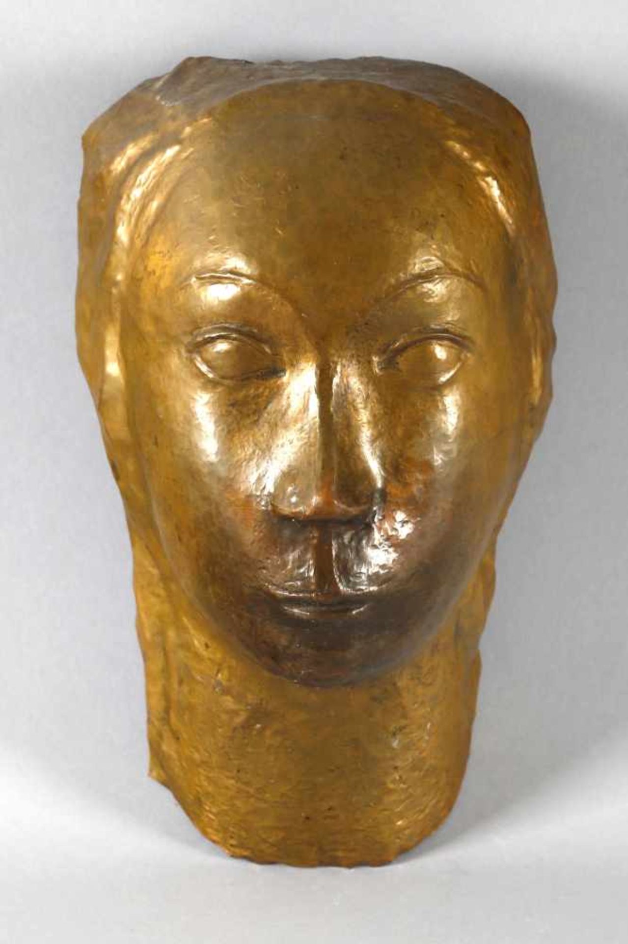 Gesichtsmaske einer Frau, wohl um 1900Kupfer getrieben, hinten mit Bügel, als Wandobjekt, H: 26 cm