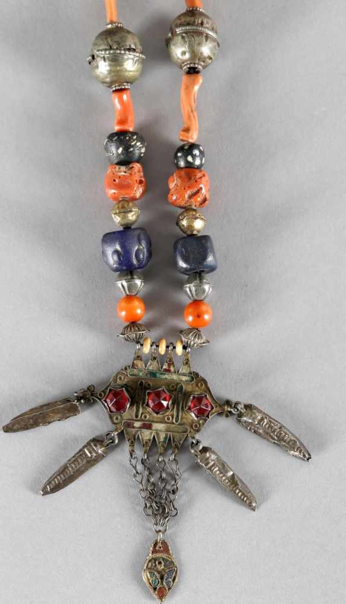 Collier mit symmetrisch angeordneten Perlen verschiedener Materialien wie Silber, Koralle, Glasdiese