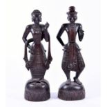 A pair of large carved hardwood South Asian figures on naturalistic bases with lotus leaf