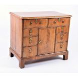 An early Georgian walnut veneered chest probably converted from a kneehole desk, with a quarter-