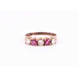 A 9ct yellow gold, ruby and diamond ring set with three round-cut diamonds of approximately 0.30