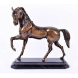 A 20th century bronze model of a horse in galloping stance, raised on a shaped and stepped marble