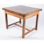 A 19th century or earlier provincial French fruit wood table the folding hinged squared top