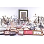 A large collection of miniature ornamental penny farthings in mixed materials and designs,