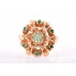 A 14ct yellow gold and emerald floral cluster ring of raised design, set with round-cut emeralds,