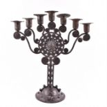 An Austrian secessionist period Menorah in hammered iron, with scrollwork and stylised spiral
