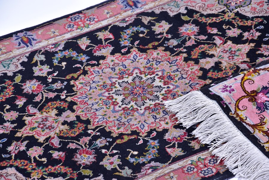 A near pair of small Iranian rugs with fringed ends, each with central black field designed with - Image 4 of 5