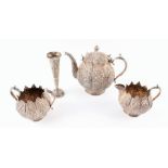 A Indian silver three piece tea set late 19th century, of circular form, with chased foliate