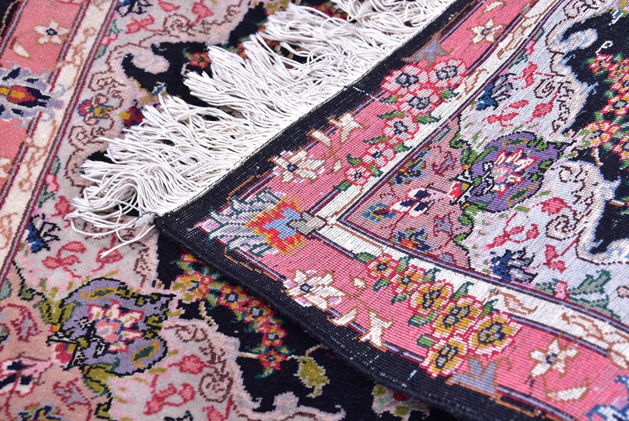 A near pair of small Iranian rugs with fringed ends, each with central black field designed with - Image 2 of 5