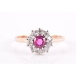 An 18ct yellow gold, diamond, and ruby cluster ring set with a round-cut ruby surrounded with a