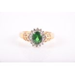 A yellow gold and green garnet ring with foliate decoration to shoulders inset with small diamonds.