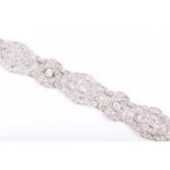 A platinum and diamond bracelet the six openwork links of geometric Art Deco style, inset with round