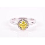 An 18ct white gold and yellow diamond ring set with a round brilliant-cut fancy yellow diamond of