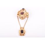 A Victorian garnet and filigree pendant brooch set with a central garnet and smaller oval-cut garnet