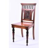 An Edwardian hall chair with pierced rail back and carved floral decoration, the plain seat on
