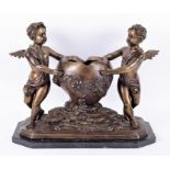 A 20th century patinated bronze cherub jardiniere modelled as a pair of winged cherubs holding the