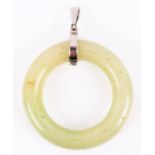 A Chinese green hardstone pendant of bi form, the smooth circular pendant approximately 3.6 cm