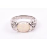 A platinum, diamond, and opal ring set with an oval cabochon opal, the shoulders inset either side