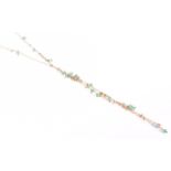 A yellow metal and emerald opera-length necklace with varied length gold tassel drops strung with