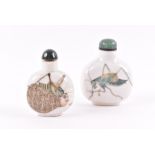 Two Chinese snuff bottles both with enamelled crickets to the oval bodies and nephrite stoppers. (