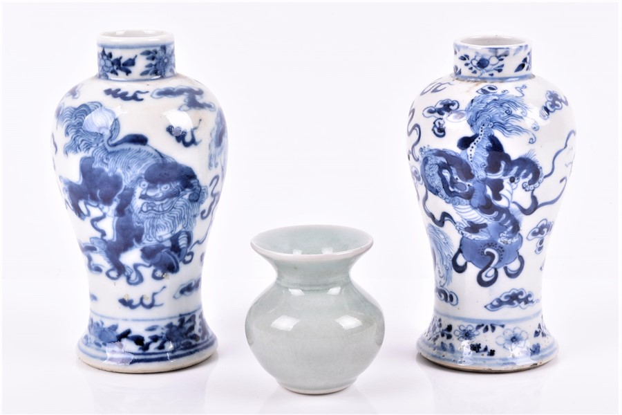 A similar pair of 19th century Chinese vases of baluster form, decorated with lion dogs of fo