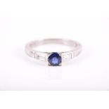 A platinum, diamond, and sapphire ring set with a round-cut blue sapphire of approximately 0.70