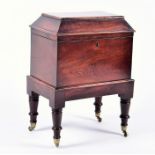 A Regency mahogany cellaret of sarcophagus form, the raised lid above a rectangular body supported