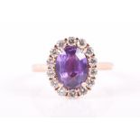 An 18ct rose gold, diamond, and purple sapphire cluster ring set with an oval-cut sapphire of