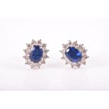 A pair of diamond and sapphire earrings of oval cluster form, 9 x 10 mm, 3 grams.