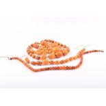 An amber beaded necklace (stringing broken) with various sized butterscotch amber beads, together