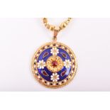 An 18ct yellow gold and enamel pendant on chain of circular form, highlighted with floral details