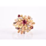 An unusual yellow metal, diamond, and ruby floral cluster ring in the Modernist taste, the raised