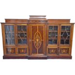 A large Edwardian mahogany and inlaid breakfront bookcase the central cupboard door with a classical