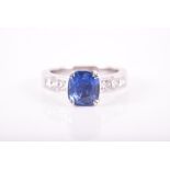An 18ct white gold, diamond, and sapphire ring set with a rectangular cushion-cut sapphire of