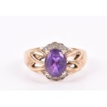 A 9ct yellow gold, diamond, and amethyst ring set with a mixed oval-cut amethyst with openwork