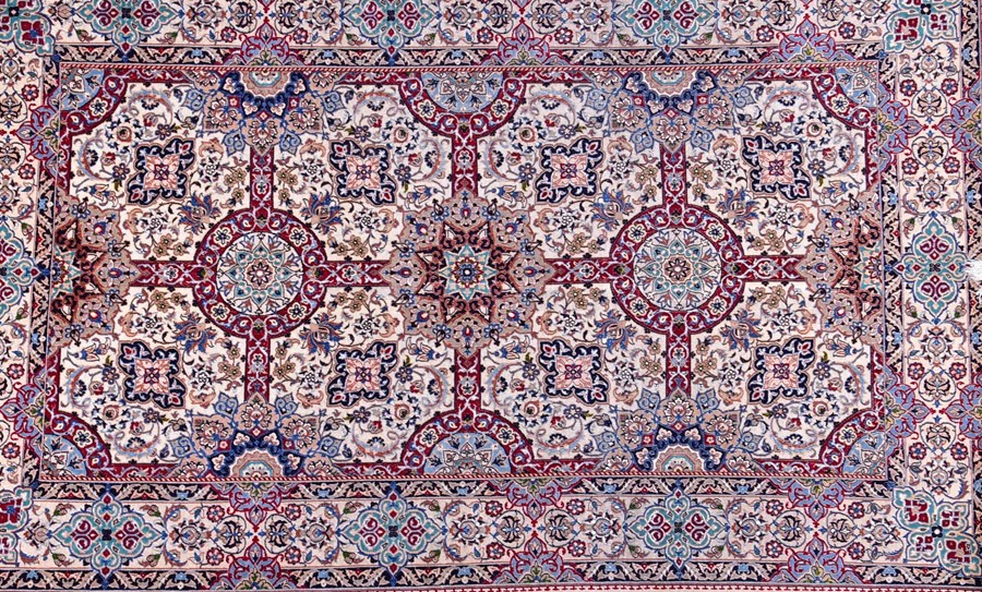 A contemporary Iranian part silk carpet with fringed ends, the ivory field decorated with a stylised