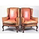 A pair of 20th century leather wingback armchairs with curved arms on four cabriole legs, 82 cm wide