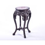 A small late 19th / early 20th century Chinese carved hardwood jardiniere stand decorated with a