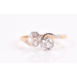 An 18ct yellow gold, platinum, and diamond crossover ring set with two old-cut diamonds of