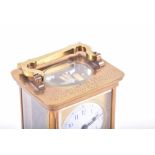 A brass bound Carriage clock with engraved inscription and enameled dial.