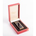 A Cartier lighter with its original box of pentagon form, 18k gold plate and black enamel
