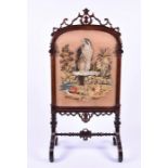 A large Victorian mahogany carved fire screen  surmounted by shield and scroll decoration, the