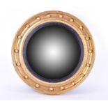 A Regency style giltwood convex mirror of circular form with ball shot and egg and dart border,