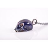 An unusual silver and dark blue enamel skull pendant with cabochon ruby eyes, approximately 1.5 cm