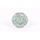 A diamond and emerald set cocktail ring of circular form, centred with a round brilliant-cut diamond