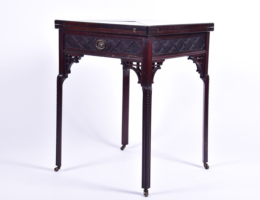 A 19th century rosewood envelope card table with pierces and carved frieze, opening to reveal a