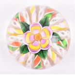 A floral paperweight by John Deacons dome shaped with five petalled purple and yellow central flower